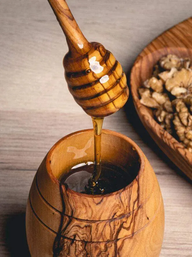 Cuillère à miel en bois naturel utilisée pour servir un miel artisanal